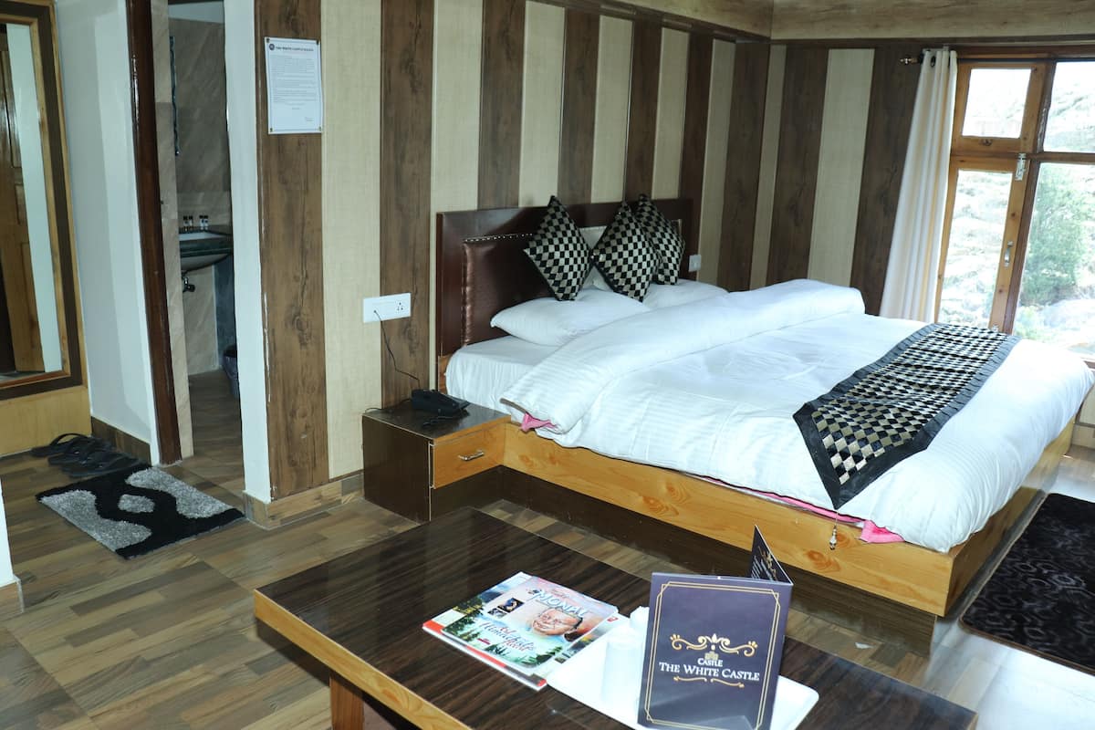 A wooden-paneled bedroom with a bed, a nightstand, and a magazine on the table.