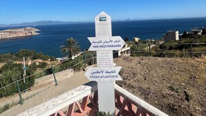 Un cartel con flechas direccionales que apuntan a varios destinos, incluyendo el Mar Mediterráneo y el Océano Atlántico.