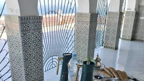 Comedor con una mesa dispuesta para el desayuno, incluyendo platos, cubiertos y una botella de agua.
