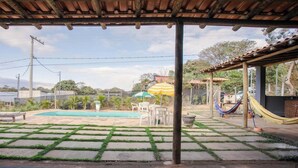 A covered outdoor area with a pool, seating, and a hammock. - Sítio em Jaboticatubas com Área de Lazer Completo (Jaboticatubas)