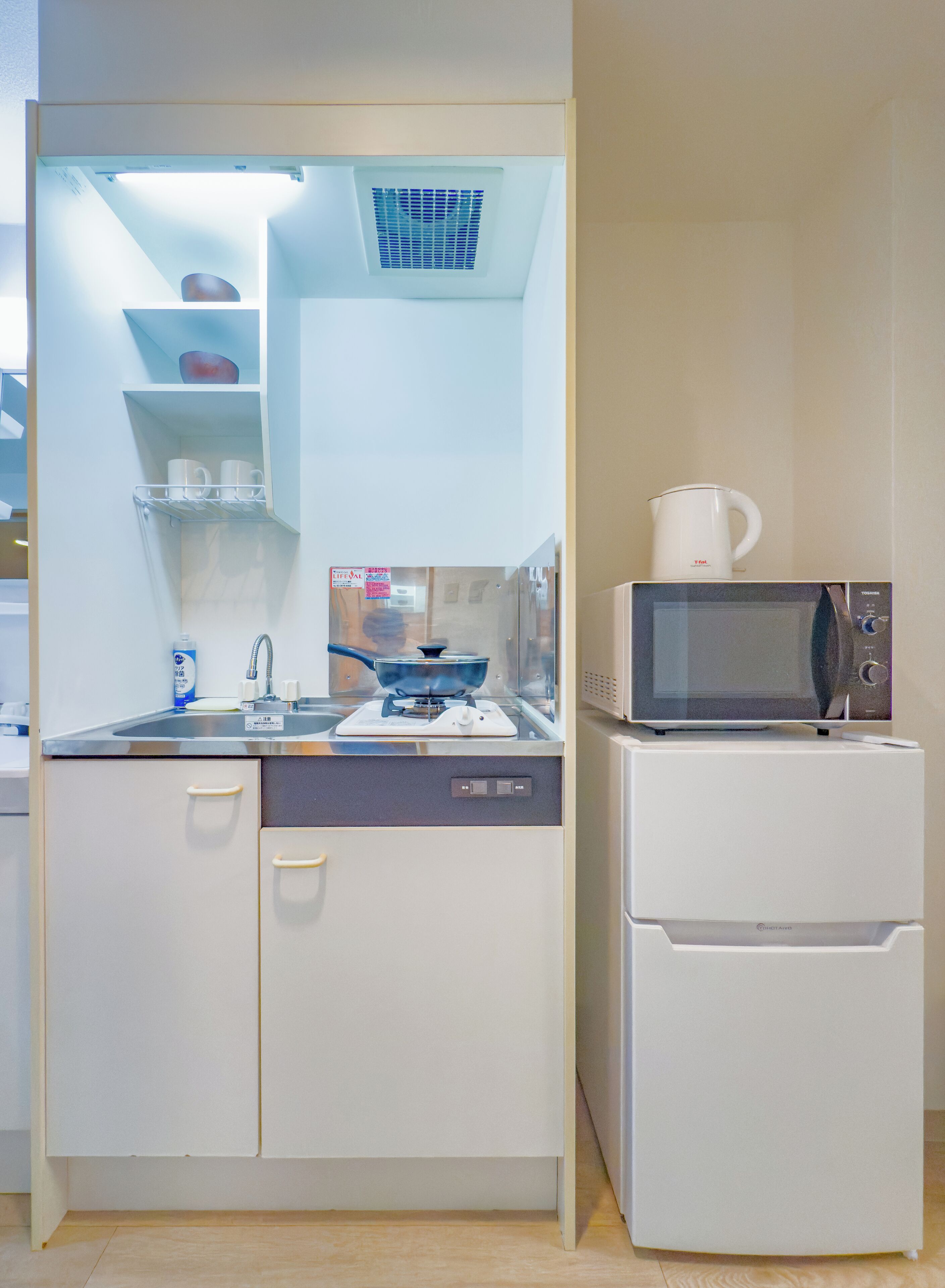 A compact kitchen with a microwave, a stove, and a sink.