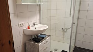 Une salle de bain moderne équipée de toilettes, d’un lavabo et d’une douche.