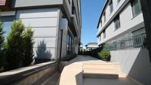 A modern building with a narrow pathway leading to a set of steps. - Professionally Maintained Spacious New Suites 2-4 (Antalya)