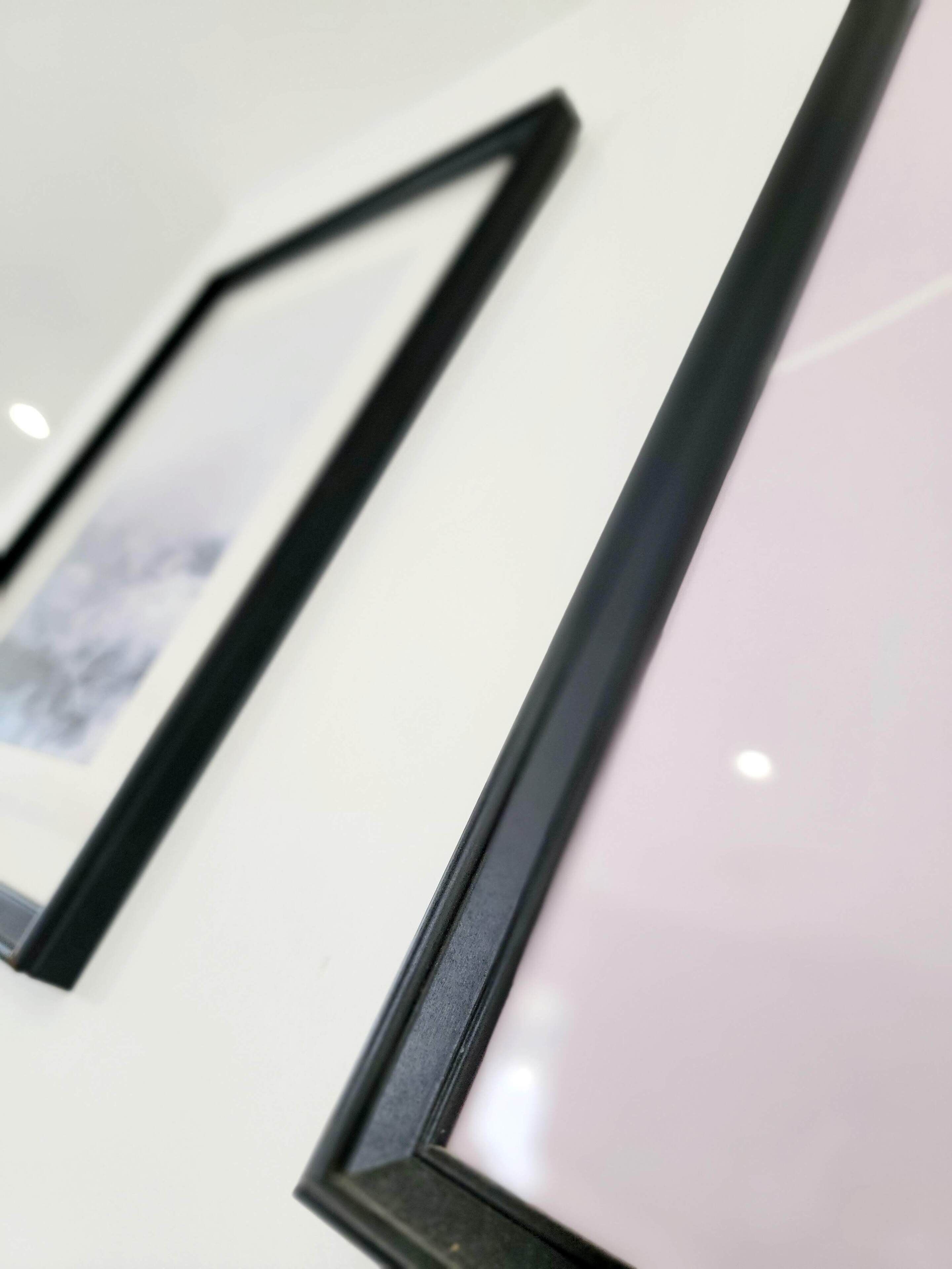 Ein Detailaufnahme der Seite eines weißen Autos, mit schwarzem Rahmen um die Scheibe.