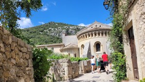 A stone pathway leading to a historic building with arches and a cross on top, surrounded by greenery and a clear blue sky. - Magnificent maisonnette with private pool, 25min from beaches, 5 minutes from Montpellier (Juvignac)