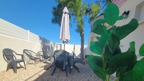 A patio area with outdoor furniture, a table, and a potted plant. - Magnificent maisonnette with private pool, 25min from beaches, 5 minutes from Montpellier (Juvignac)