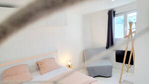 A modern bedroom with a bed, bedside table, and a window with curtains. - Magnificent maisonnette with private pool, 25min from beaches, 5 minutes from Montpellier (Juvignac)