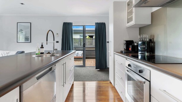 Una cocina moderna con una isla grande, electrodomésticos de acero inoxidable y vistas al exterior.