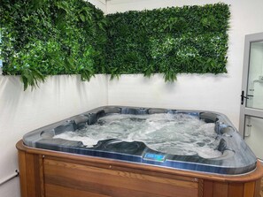 A hot tub with a digital control panel, surrounded by a wooden cabinet. - Tarawera Twins - Two Homes, Spa Pools, Sleeps 16 (Rotorua)