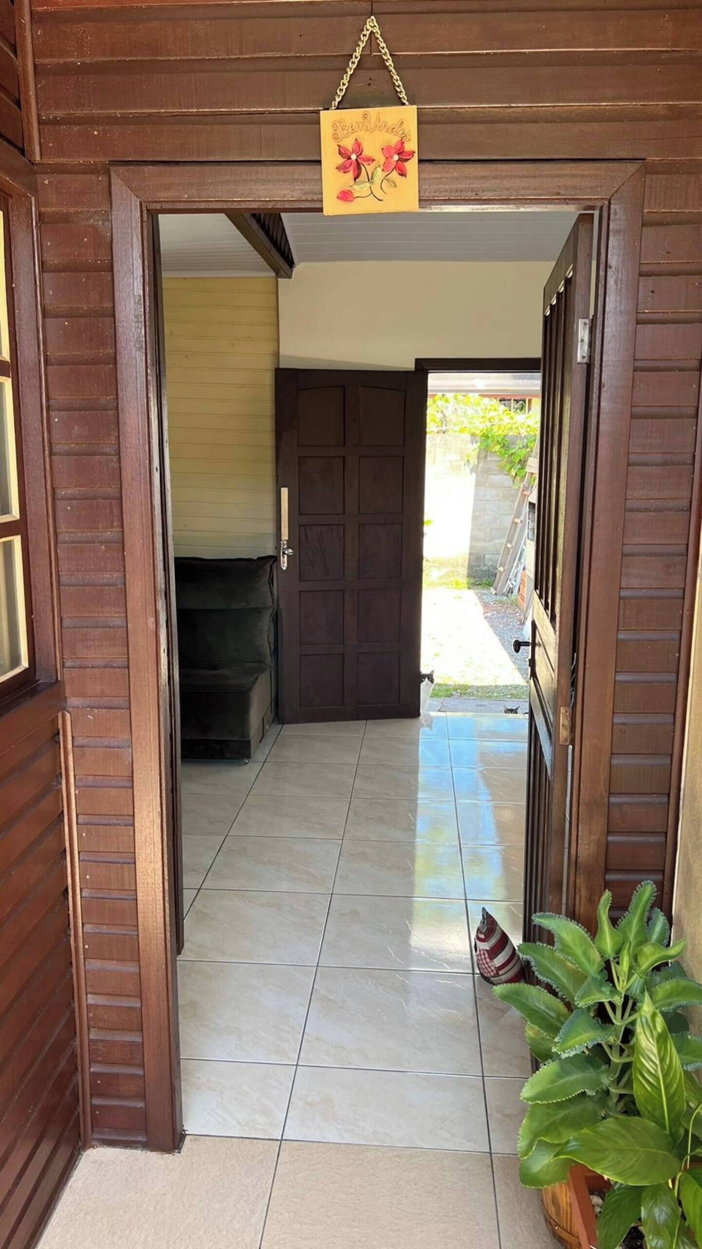 A wooden entrance with a tiled floor leading to a dark interior.