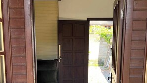 A wooden entrance with a tiled floor leading to a dark interior.
