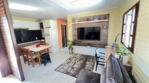 A compact living space with a kitchen, dining area, and a seating area with a sofa and TV.