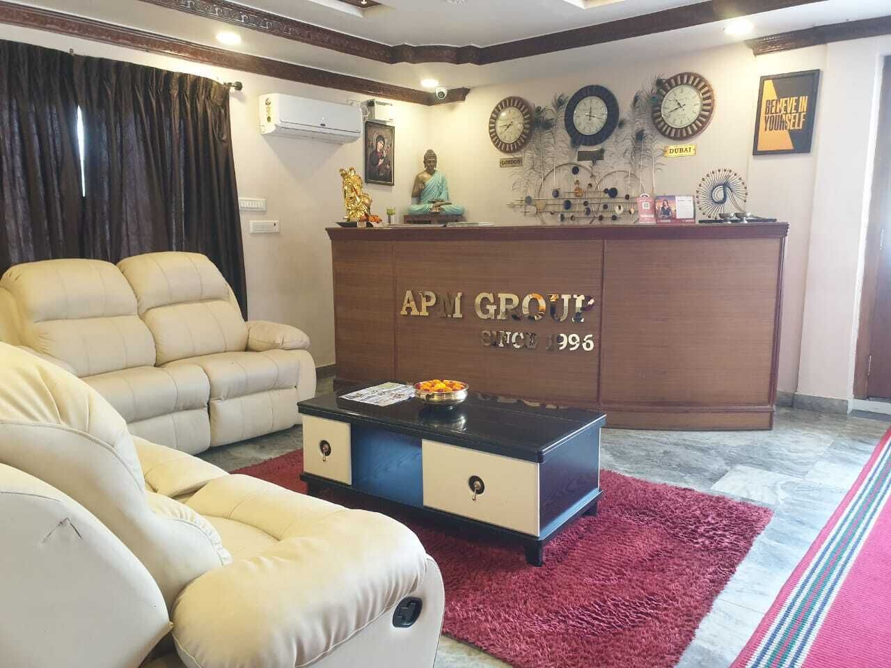 Una sala de estar con un sofá color beige, una mesa de centro y un aparador de madera con el texto "APM GROUT" y "DESDE 1996".