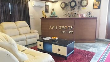 Una sala de estar con un sofá color beige, una mesa de centro y un aparador de madera con el texto "APM GROUT" y "DESDE 1996".