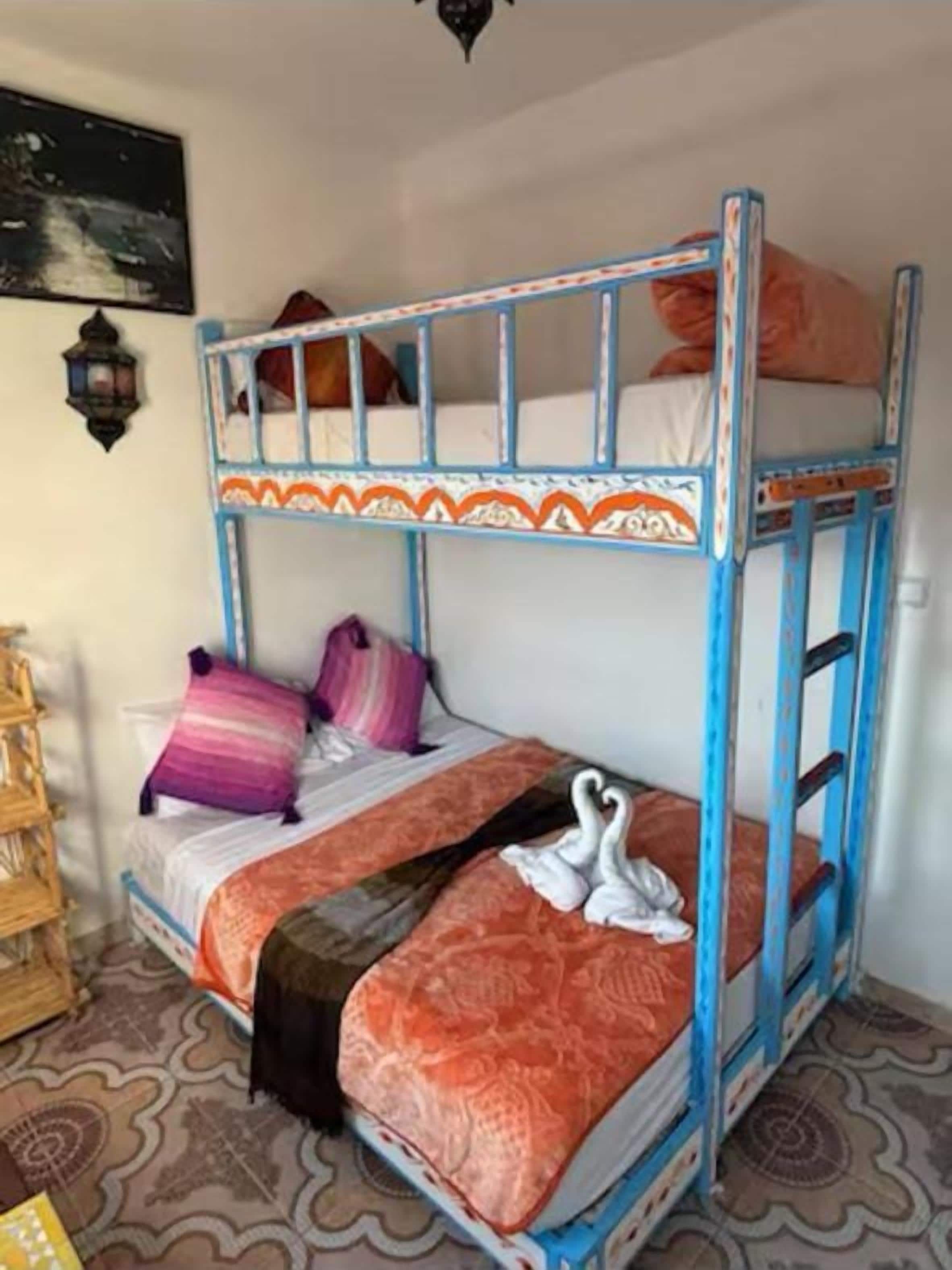 A bunk bed with two levels, each with pillows and a blanket.
