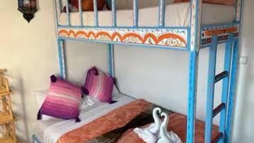 A bunk bed with two levels, each with pillows and a blanket.