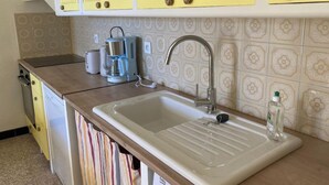 A kitchen with a sink, a coffee maker, and yellow cabinets. - La petite maison du Couvent des Ecrevisses, sleeps 4 in the heart of Barjols (Barjols)