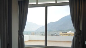 A hotel room with a large window, a bed, and a carpeted floor. - Destination Hotel Gilgit (Gilgit)