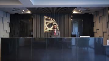 A reception desk with a modern design, a digital display, and a security camera.