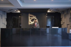 A reception desk with a modern design, a digital display, and a security camera. - Destination Hotel Gilgit (Gilgit)