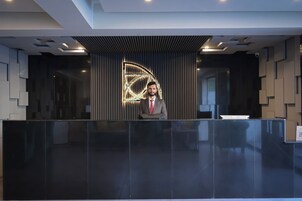 A reception desk with a modern design, a digital display, and a security camera.