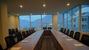 A conference room with a long table and chairs, large windows with a mountain view, and a carpeted floor. - Destination Hotel Gilgit (Gilgit)