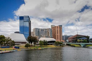 Paesaggio urbano con edifici moderni, tra cui un grattacielo Deloitte e un centro congressi lungo un fiume.
