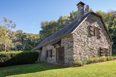 A stone cottage with a sloped roof, wooden shutters, and a chimney.. Holiday Home 'Baou' with Mountain View, Private Terrace and Wi-Fi
