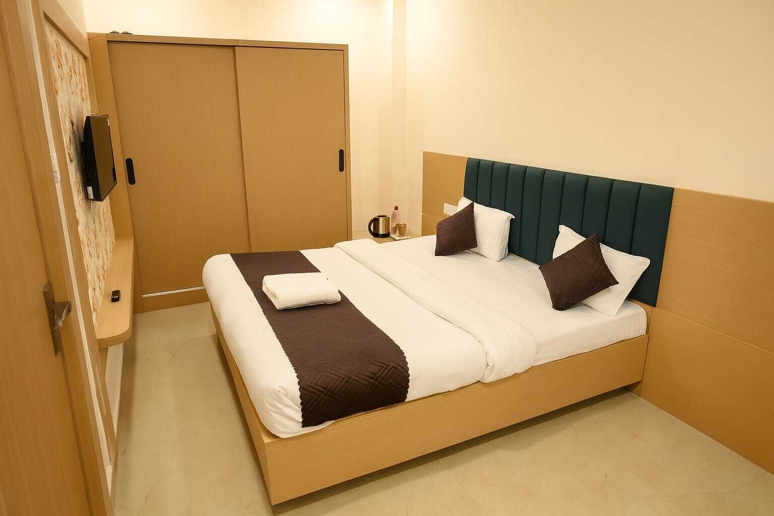 A neatly made bed with a wooden frame, a headboard, and multiple pillows.