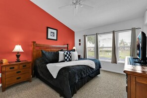 A bedroom with a bed, a nightstand, a lamp, a television, and a window with blinds. - SPD2319 Summary:<br>Our (Kissimmee)