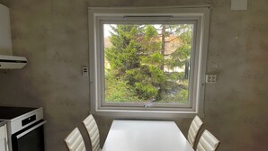 A small kitchen with a window, a table, and four chairs. - 3-bedroom apartment with free parking in central Tromsø (Troms)