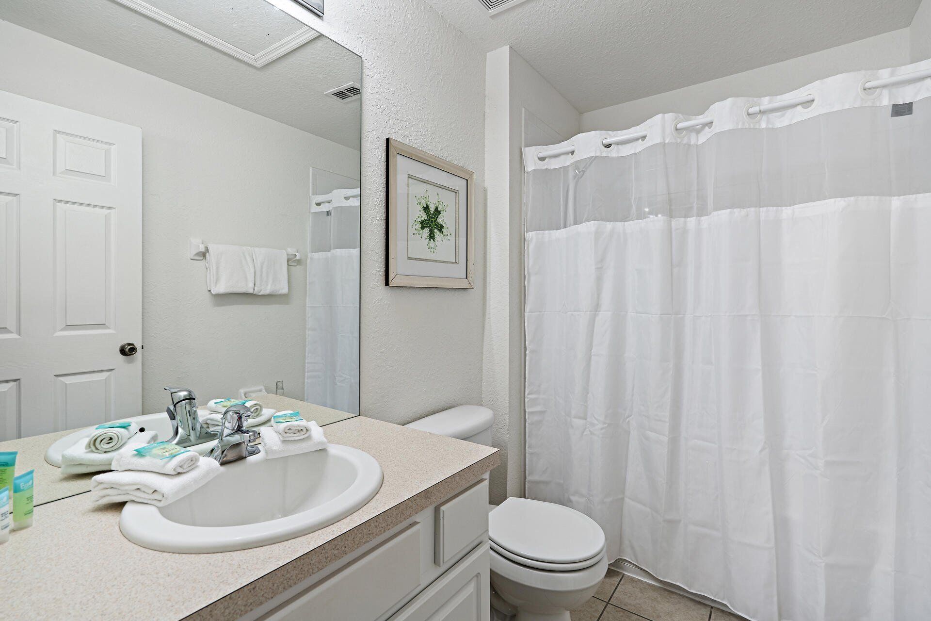 Ein Badezimmer mit Waschbecken, Toilette und Duschvorhang.