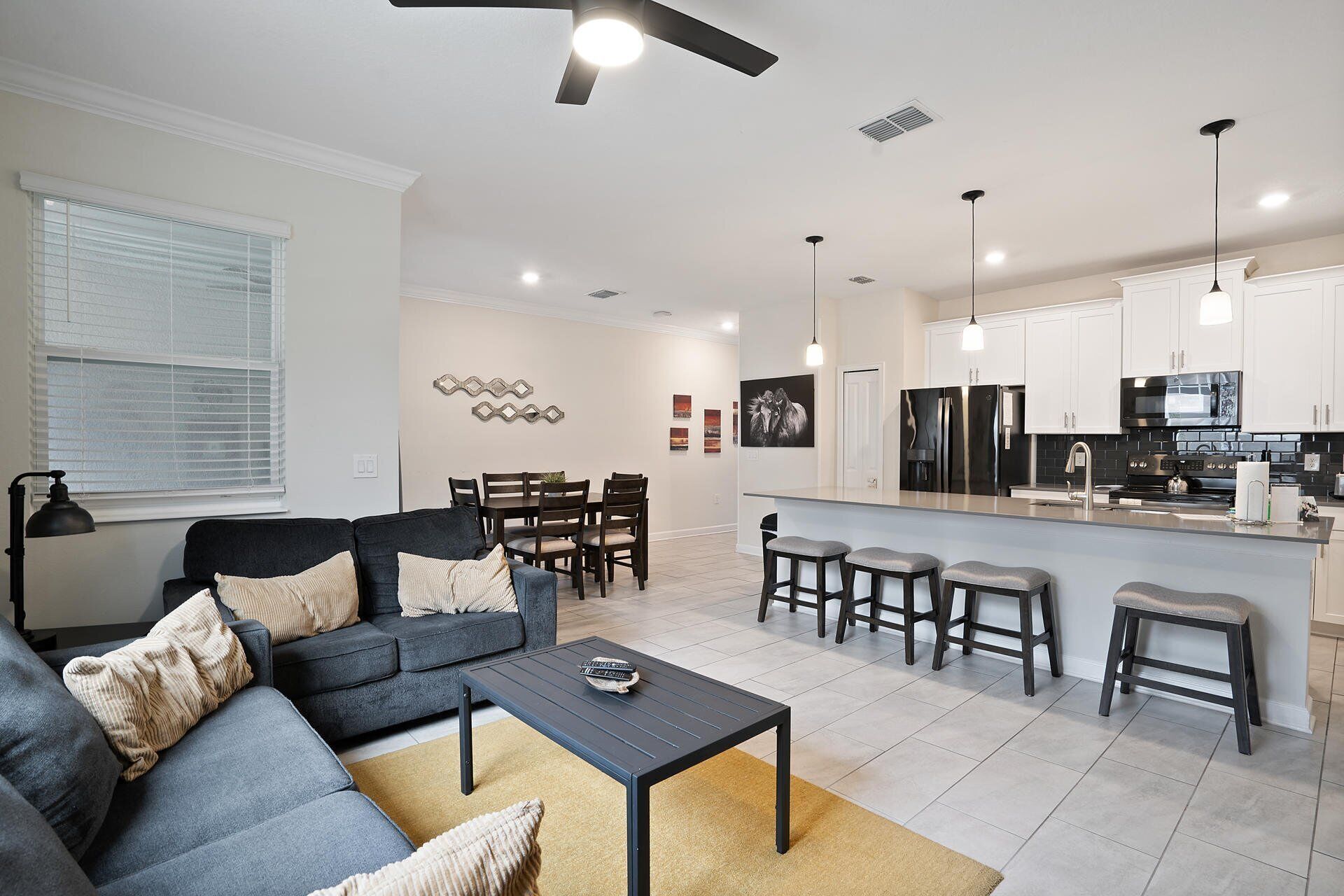 A modern living room with a sofa, coffee table, and dining area.