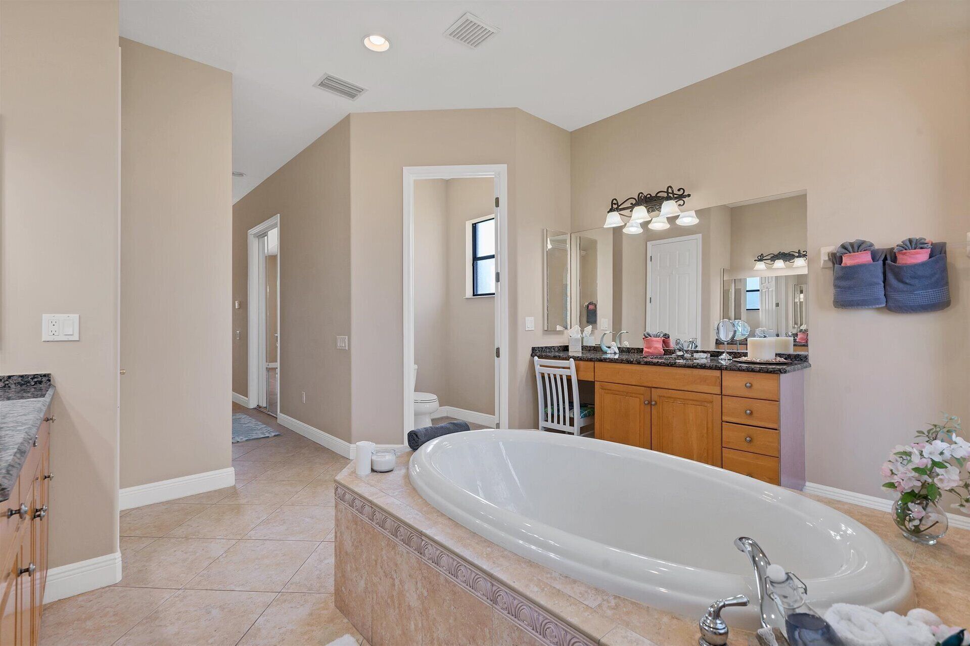 A modern bathroom with a freestanding bathtub, a vanity with a large mirror, and a walk-in shower.