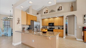 A spacious kitchen with granite countertops, wooden cabinets, and stainless steel appliances. - OBS119 Summary:<br>Cape (Cape Coral)