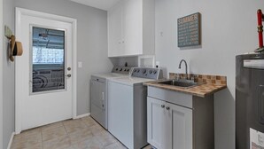 A compact kitchen with a washing machine, a sink, and a stove. - Cod917 (Punta Gorda)