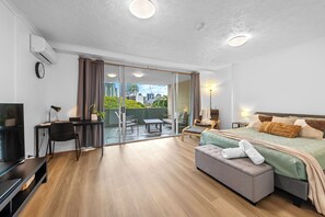A modern hotel room with a balcony, a bed, a desk, and a TV. - Resort-Style Comfort in the Heart of the Valley (Brisbane)