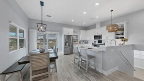 A modern kitchen with white cabinets, stainless steel appliances, and a breakfast bar. - Ga1978 (Englewood)