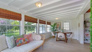 A bright, open-plan living area with a white sofa, a dining table with chairs, and large windows with wooden blinds. - HH123 Summary:<br>Welcom (Clermont)