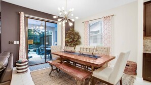 A dining area with a wooden table, cushioned chairs, and a hanging light fixture. - STC5428 Summary:<br>Solt (Davenport)