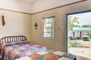 Un dormitorio con una cama, una ventana y vista a un vehículo afuera.