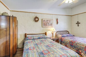 Un dormitorio con dos camas, un armario de madera, un reloj de pared y un cuadro enmarcado.
