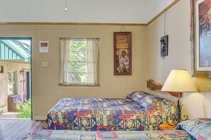 Ein Zimmer mit einem Bett, einem Fenster, einer Lampe und einem Poster an der Wand.
