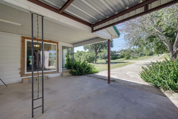 A covered porch with a concrete floor, a metal ladder, and a view of a grassy area with trees and a path. - Hike From Your Door! Pet-friendly Whitney Home (Whitney)