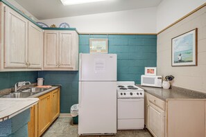 A compact kitchen with a refrigerator, stove, microwave, and sink. - Hike On-site: Lake Whitney Studio Hideaway (Whitney)