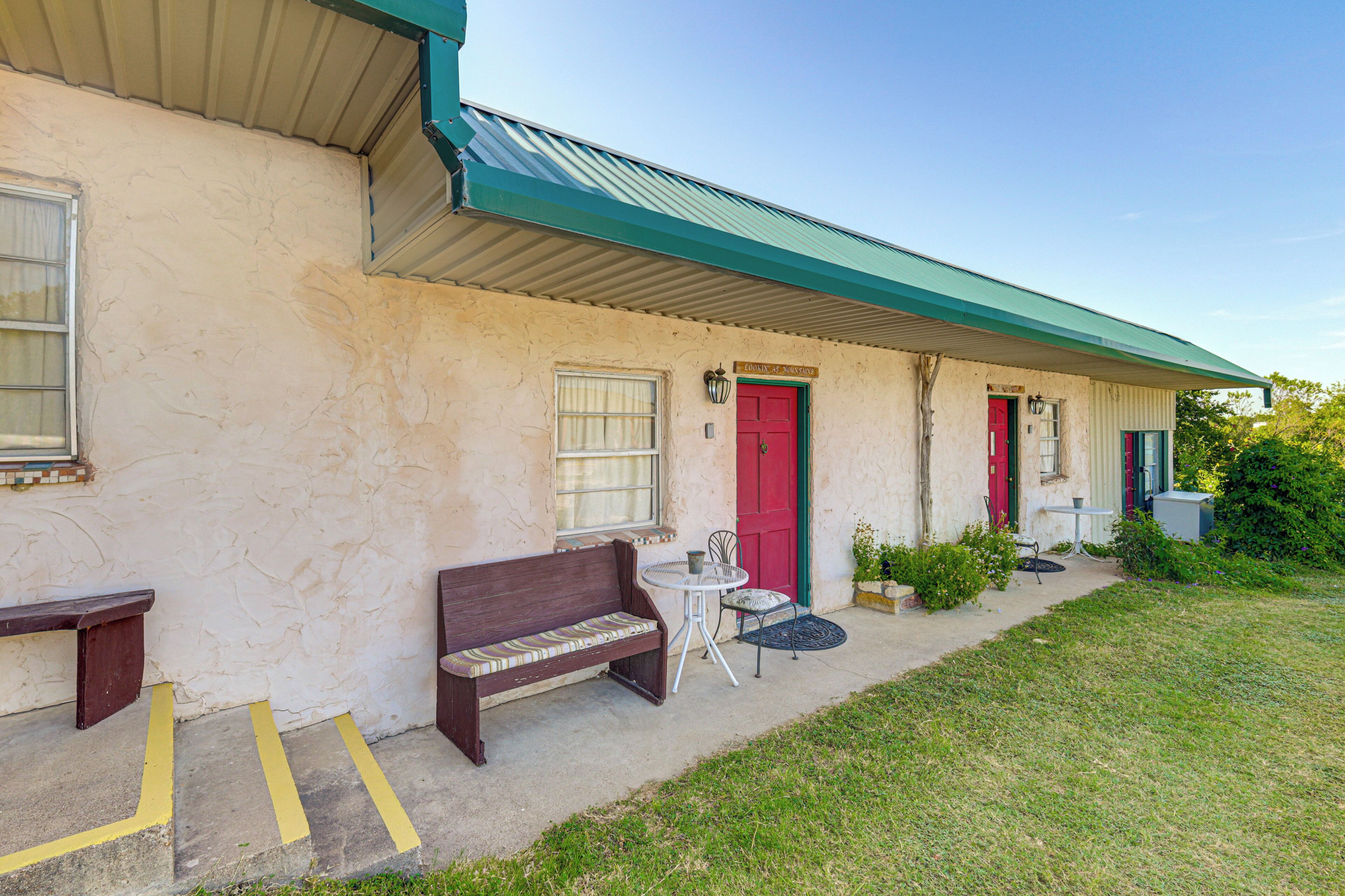 A building with a red door and a bench outside.