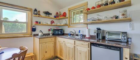 A kitchen with wooden cabinets, a dishwasher, a toaster, and various kitchen appliances.