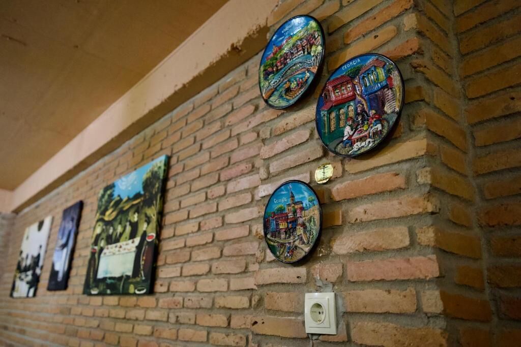 A brick wall with several decorative plates and paintings.
