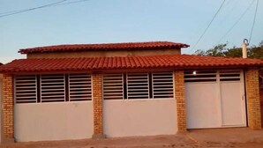 A single-story building with a red-tiled roof and two garage doors.