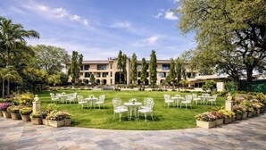 A courtyard with outdoor seating, a building with multiple floors, and a well-maintained lawn. - Daksh The Fateh Retreat - Udaipur (Udaipur)